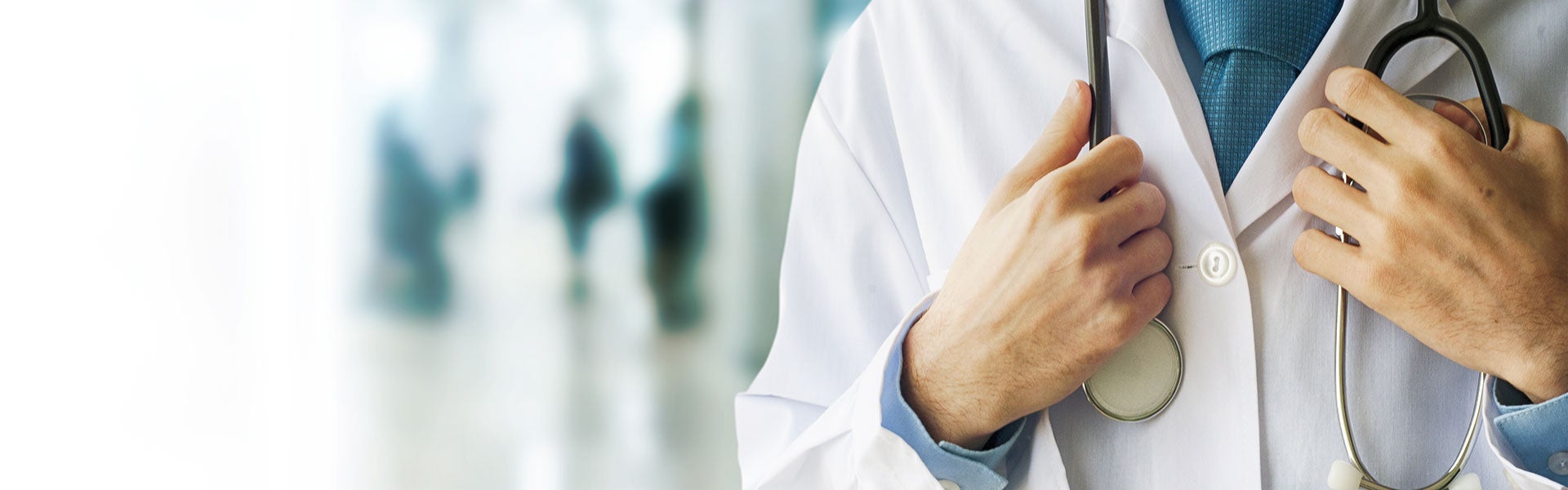 A doctor in a white coat holds a stethoscope